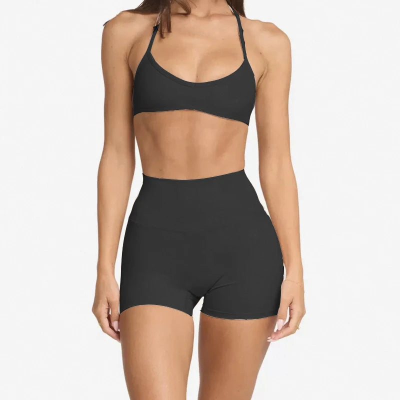 woman wearing a halter neck bra top and shorts gym set in black