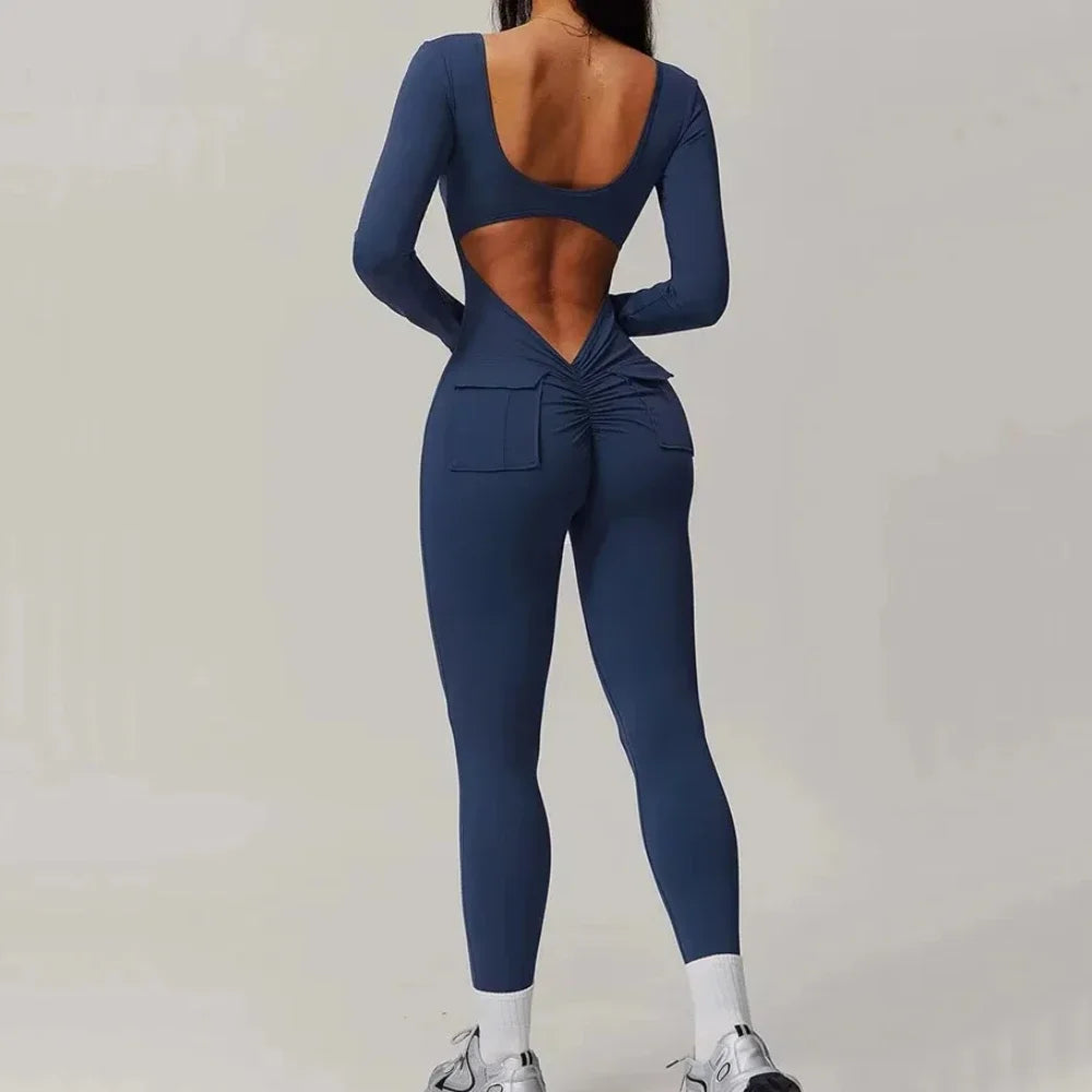 Person wearing a blue open-back jumpsuit on a plain background