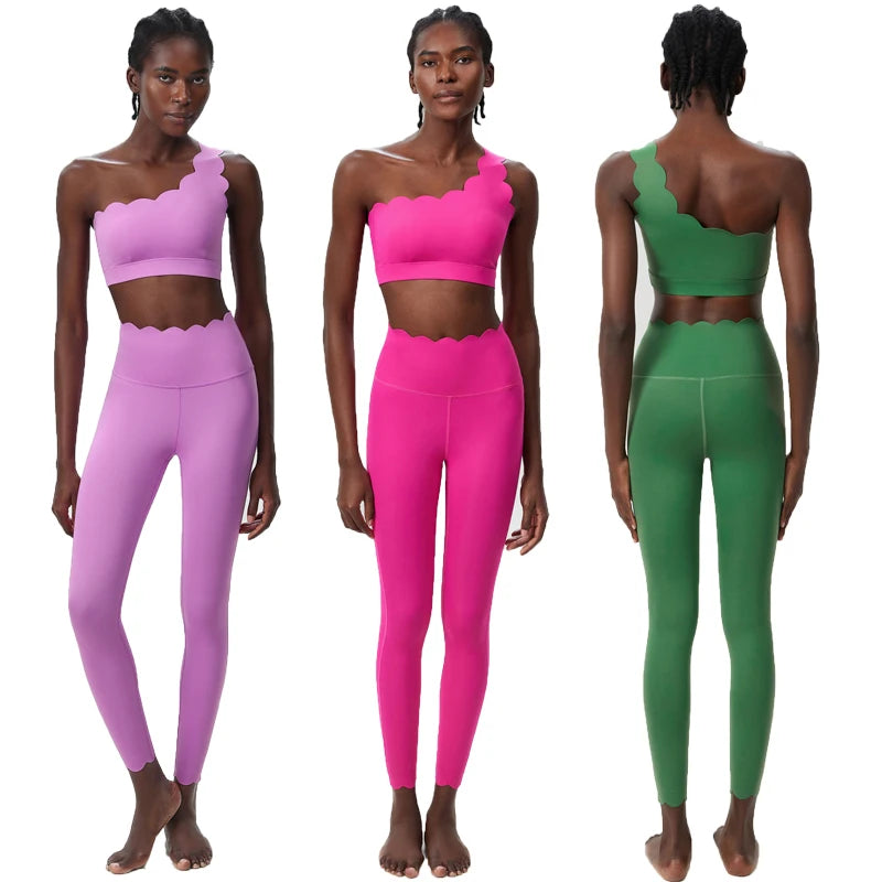 Three women modeling pink and green athletic outfits on a white background